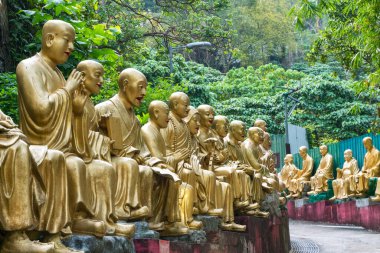 Hong Kong, 27 Mart 2019: Bulutlu bir günde ünlü On bin Buda Manastırı 'na giden Buda heykelleriyle dolu uzun ve dik merdiven