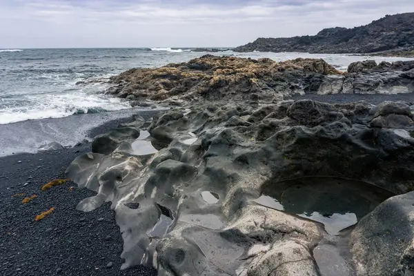 Bulutlu bir günde Tenesar yakınlarında terk edilmiş ve ıssız bir köy olan Lanzarote sahilinin manzarası.