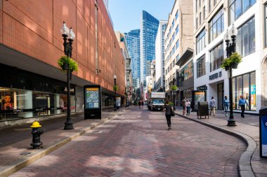 Boston, ABD - 12 Ağustos 2019: İnsanlar güneşli bir günde sokaklarda ve Boston 'un gökdelenleri arasında geziniyor