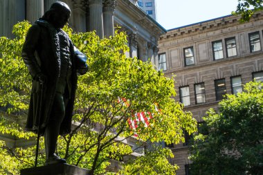 Boston, ABD - 12 Ağustos 2019: Güneşli bir günde Boston sokaklarının ve binaların arasında Old City binasının önündeki Benjamin Franklin Heykeli