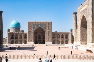 Semerkand, Özbekistan-Ağustos 12, 2023: İnsanlar, güneşli bir günde hatların saflığı ve majolikanın zarafeti ile ünlü 3 medreseden oluşan büyük bir kompleksin bulunduğu Registan Meydanı 'nı ziyaret ediyorlar.