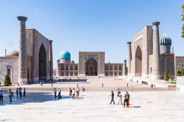 Semerkand, Özbekistan-Ağustos 12, 2023: İnsanlar, güneşli bir günde hatların saflığı ve majolikanın zarafeti ile ünlü 3 medreseden oluşan büyük bir kompleksin bulunduğu Registan Meydanı 'nı ziyaret ediyorlar.