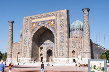 Semerkand, Özbekistan-Ağustos 12, 2023: İnsanlar, güneşli bir günde hatların saflığı ve majolikanın zarafeti ile ünlü 3 medreseden oluşan büyük bir kompleksin bulunduğu Registan Meydanı 'nı ziyaret ediyorlar.