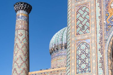 Semerkand, Özbekistan-Ağustos 12, 2023: Güneşli bir günde hatların saflığı ve majolikanın zarafeti ile ünlü 3 medreseden oluşan büyük bir tesis tarafından işgal edilen Registan meydanı.