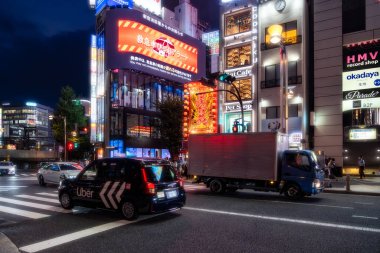 Tokyo, Japonya-Ağustos 5, 2024: İnsanlar gece Shinjuku 'nun neon ışıkları arasında yürüyorlar