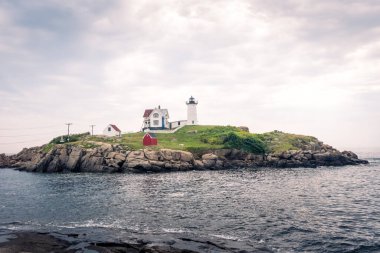 Boston, USA - August 12, 2019:View of the Nubble Lighthouse, one of the most famous lighthouses in Maine during a sunny day clipart