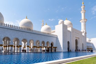 Abu Dabi, Birleşik Arap Emirlikleri - 15 Mart 2023: İnsanlar güneşli bir günde Şeyh Zayed Büyük Camii 'ni ziyaret ediyor.