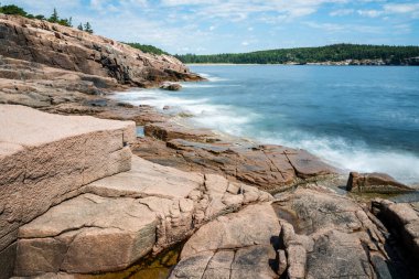 Güneşli bir günde Maine 'deki Acadia Ulusal Parkı' nda ve ormanında yürümek