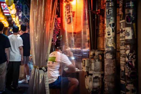 Tokyo, Japonya-Ağustos 5, 2024: İnsanlar akşam saatlerinde Shinjuku sokaklarındaki küçük yerlerde yemeğe ya da bir şeyler içmeye giderler.