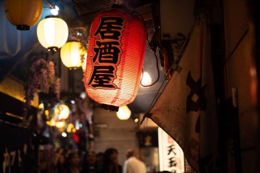 Tokyo, Japonya-Ağustos 5, 2024: Restoran fenerleri müşterileri gece boyunca Shinjuku sokaklarındaki küçük yerlerde yemek veya içmek için çeker.