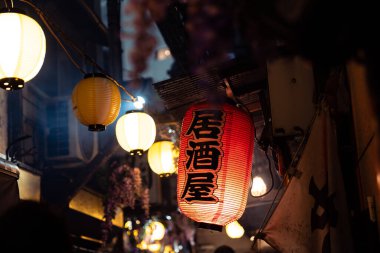 Tokyo, Japonya-Ağustos 5, 2024: Restoran fenerleri müşterileri gece boyunca Shinjuku sokaklarındaki küçük yerlerde yemek veya içmek için çeker.