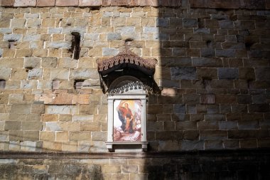 Lucca, İtalya-16 Şubat 2025: Güneşli bir günde Lucca 'da San Frediano Bazilikası' nın duvarında dini bir simge