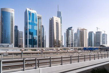 Dubai, Birleşik Arap Emirlikleri - 17 Mart 2023: Güneşli bir günde Dubai sokaklarından birini takip eden bir dizi modern gökdelen