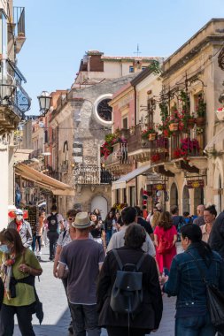 Sicilya, İtalya-12 Mayıs 2022: İnsanlar güneşli bir günde, müstehcen bir Taormina caddesinde yürüyor.