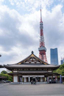 Tokyo, Japonya-Ağustos 6, 2024: Güneşli bir günde arka planda turuncu Tokyo kulesi olan Zojo ji Tapınağının dikey görüntüsü