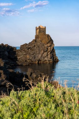 vertical photograph of  the ancient tower of Santa Tecla used as an observation and guard point in Sicily during a sunny day