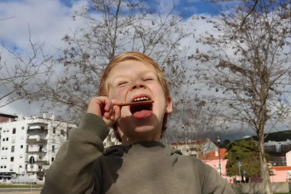 Ξανθό Αγόρι Ανοίγει Στόμα Του Και Βάζει Μέσα Ένα Μπισκότο — Φωτογραφία Αρχείου