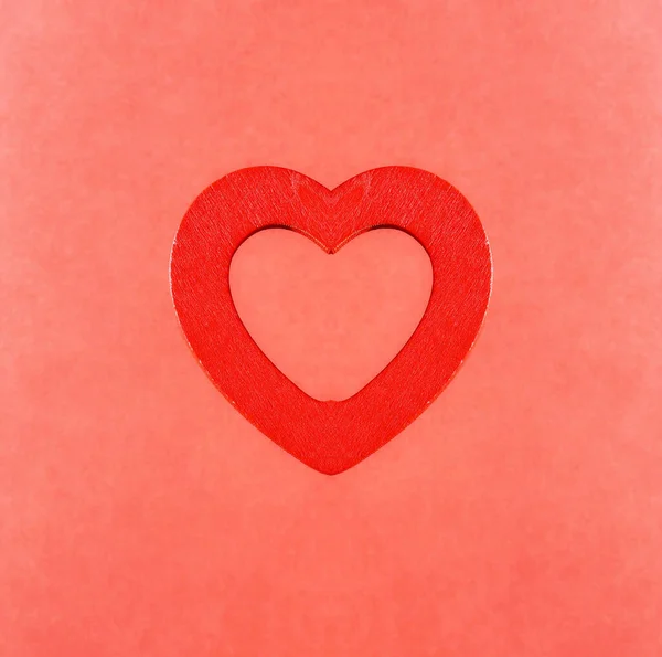 Bright red heart on a light red background. Kaleidoscopic background design.
