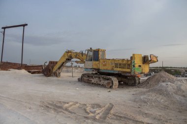 Uralsk, Kazakistan (Kazakistan), 4.05.2023 - Paslı eski bir kazıcı kovayı Batı Kazakistan 'ın Uralsk kentindeki Melovye Gory köyünde bir kireçtaşı ocağına indirdi. Kireçtaşı ocağında özel ekipman.