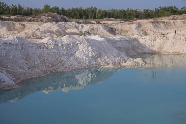 stock image Blue water from melt water at a lime quarry in the village of Melovye Gorki, West Kazakhstan region, Uralsk city. Lime quarry for the production of bricks. Piles of chalk stones.