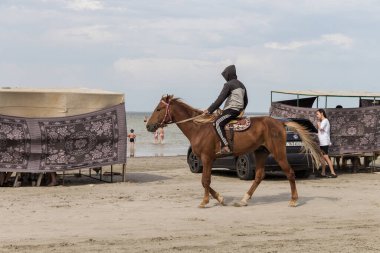 Shalkar Gölü, Kazakistan (Kazakistan), 29.07.2023 - Batı Kazakistan bölgesinde Shalkar Gölü kıyısında at süren genç bir adam