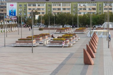 Atyrau, Kazakistan (Kazakistan), 04.09.2023 - Atyrau kentindeki İsatay ve Makhambet Meydanı 'ndaki banklarda insanlar oturuyor