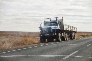 Aktau, Kazakistan (Kazakistan), 21.10.2023 - Bir kamyon yolda alev aldı. Arabanın kaputu ve radyatör ızgarasının altından ateş ve duman çıkıyor. Arabanın motoru yanıyor..
