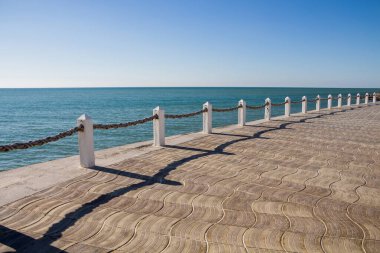 İpli deniz çitleri. Kıyı boyunca çitler. Deniz kenarındaki bariyerler. İple beton direkler. İpli iletiler.
