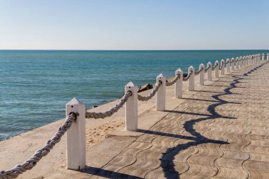 İpli deniz çitleri. Kıyı boyunca çitler. Deniz kenarındaki bariyerler. İple beton direkler. İpli iletiler.