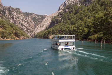 Türkiye (Türkiye), Alanya, 07.09.2023: Türkiye 'deki Yeşil Kanyon' da bir gezi gemisi (feribot) denize açılıyor. Türkiye 'nin güzel doğası. Dağlar ve göl.