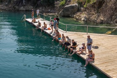 Türkiye, Manavgat, 07.09.2023: Türkiye 'deki Yeşil Kanyon Gezisi. Turistler kıyıya yakın rıhtımda balık tutuyor. Türkiye 'ye Seyahat.