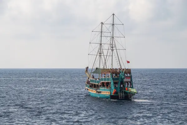 Türkiye (Türkiye), Alanya, 09.09.2023: Turistlerle dolu bir gezi gemisi Akdeniz boyunca hareket ediyor. Türkiye 'de bir gemiyle deniz gezisi. Ejderha geminin kuyruğunda..