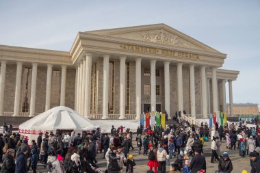 Uralsk (Oral), Kazakistan, 22.03.2024 - Kazakistan 'da Nauryz tatili. Nauryz bayramında bir kalabalık Atameken Sanat Merkezi 'nin arka planına karşı. Tatilde Kazak yurdu.