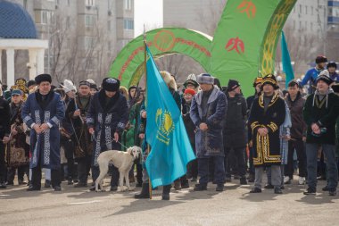 Uralsk (Oral), Kazakistan, 22.03.2024 - Kazakistan 'da Nauryz tatili. Nauryz bayramında Kazak milli kostümlü insanlar. Kazak bayrağı taşıyan adam..