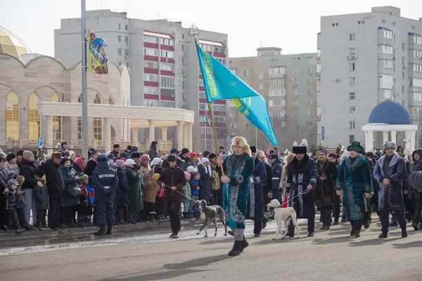 Uralsk (Oral), Kazakistan, 22.03.2024 - Kazakistan 'da Nauryz tatili. Nauryz bayramında bir adam Kazak bayrağı taşıyor. Kazakların köpekleri Tazy.