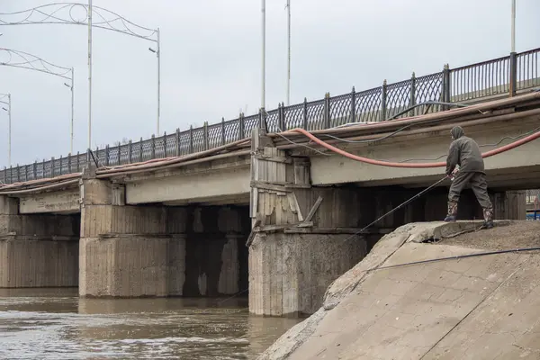 Uralsk, Oral, Kazakistan (Kazakistan), 07.04.2024 - Bir adam Uralsk kentindeki Chagan Nehri üzerindeki köprünün yakınında balık tutuyor.