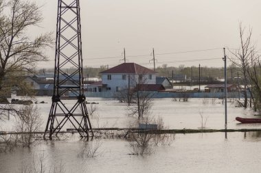 Kazakistan 'da sel. Şehir suyla dolmuştu. Nehir kıyılarından taştı. Tarlada eriyen su. Sel suyunda elektrik hattı desteği.