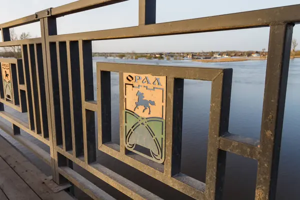The logo of the city of Uralsk on the railing of a road bridge. Road bridge over the Ural River.