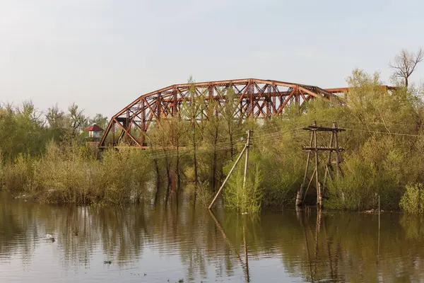 Uralsk şehrindeki Chagan Nehri 'ne demir demiryolu köprüsü dökün. Nehrin doğuşu. Nehir kıyılarından taştı..