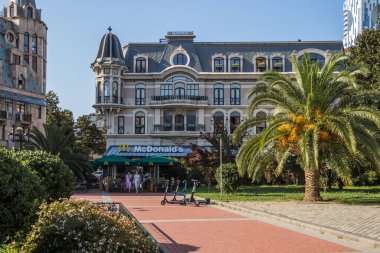 Gürcistan, Batumi, 28.08.2024: McDonald 's Avrupa Meydanı' nda modern bir şato tarzı binada. Mobiletler ve Avrupa Meydanı 'nda bir palmiye ağacı. Georgia 'ya git. Batum simgeleri.
