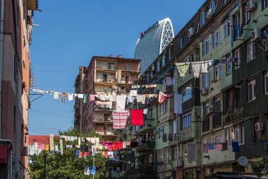 Gürcistan, Batumi, 28.08.2024: Batumi sokaklarında çamaşır kurutma. Batum rengi. Georgia 'da eski apartman binaları ve giysiler kuruyor. Marriott Oteli, eski apartmanların arka planına karşı. Georgia 'ya git..