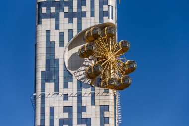 Gürcistan, Batumi, 28.08.2024: Gökdelen Batum Kulesi Dönme dolabı. Batumi 'de bir gökdelenin ön cephesinde dönme dolap. Georgia 'ya git. Batumi içinde Cazibe.