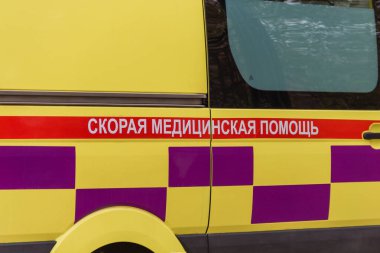 The inscription Emergency Medical Care on an ambulance in Kazakhstan. Standard coloring of ambulances in Kazakhstan. clipart