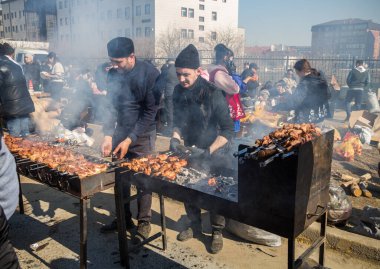 Uralsk, Kazakistan (Kazakistan), 22.03.2025: Nauryz bayramı için ızgarada şiş pişirme. Dumanlı shashlik temiz havada.