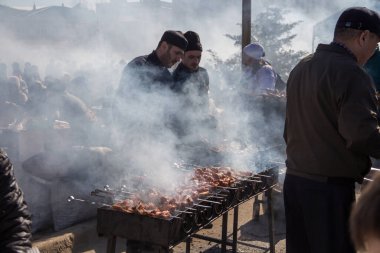 Uralsk, Kazakistan (Kazakistan), 22.03.2025: Nauryz bayramında erkekler shaşlik pişiriyor. Shashlik dumanın içinde. Izgarada shashlik pişiriyorum..