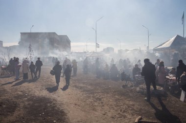 Uralsk, Kazakistan (Kazakistan), 22.03.2025: Meydan barbekü dumanlarıyla kaplandı. Nauryz bayramı kutlamaları sırasında sokakta yemek pişirmekten çıkan duman..