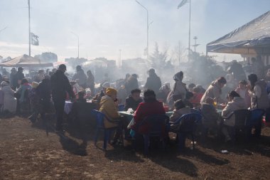 Uralsk, Kazakistan (Kazakistan), 22.03.2025: Nazarbayev Meydanı 'ndaki barbekülerden duman. Dumanın içindeki insanlar Nauryz bayramı kutlamaları sırasında sokakta barbekü yiyorlar..
