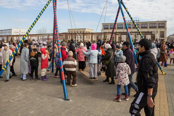 Uralsk, Kazakistan (Kazakistan), 22.03.2025: Nauryz bayramı kutlamaları sırasında çocuklar Altybakan salıncağına biniyor.