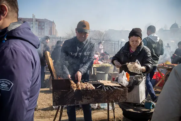Uralsk, Kazakistan (Kazakistan), 22.03.2025: Nauryz bayramı için ızgarada şiş pişirme. Dumanlı shashlik temiz havada.