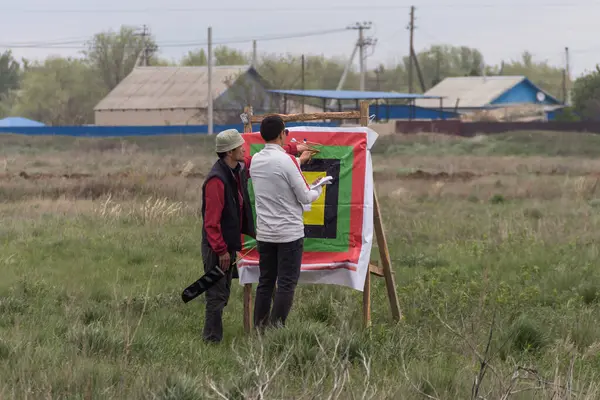 Uralsk, Kazakistan (Kazakistan), 1.05.2025: Hakim 1 Mayıs 'ta Uralsk' ta düzenlenen okçuluk turnuvasında hedefi kaç okun vurduğunu kontrol edecek.